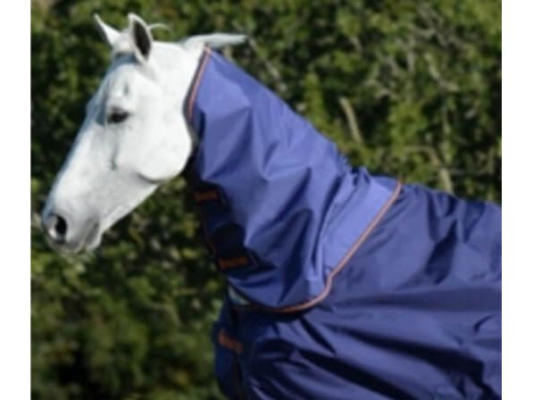 A white horse wearing a navy Bucas neck cover, photographed outdoors against a blurred green hedge.
