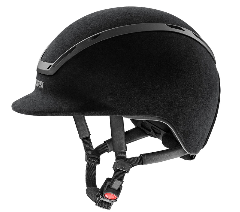 A matte black equestrian riding helmet with a visor, featuring a textured fabric shell, a glossy black trim strip, and adjustable black straps with a red release button, shown on a solid white background.