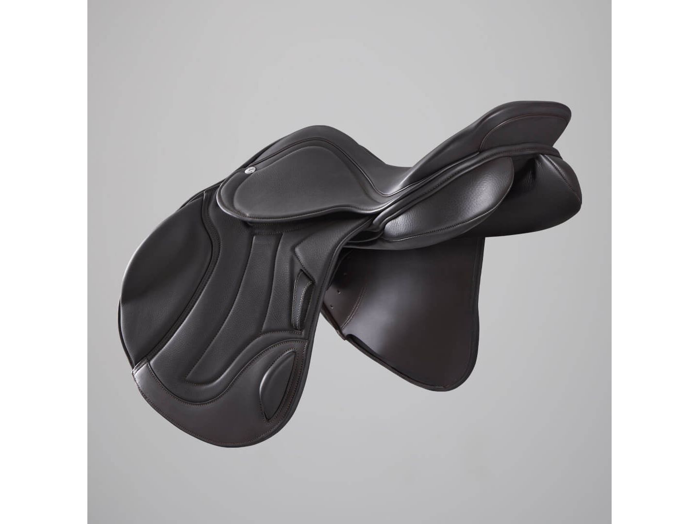 A black leather equestrian saddle with a deep seat and curved pommel, shown from a three-quarters angle against a neutral gray background.